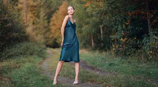 Woman wearing navy blue silk slip dress outdoors
