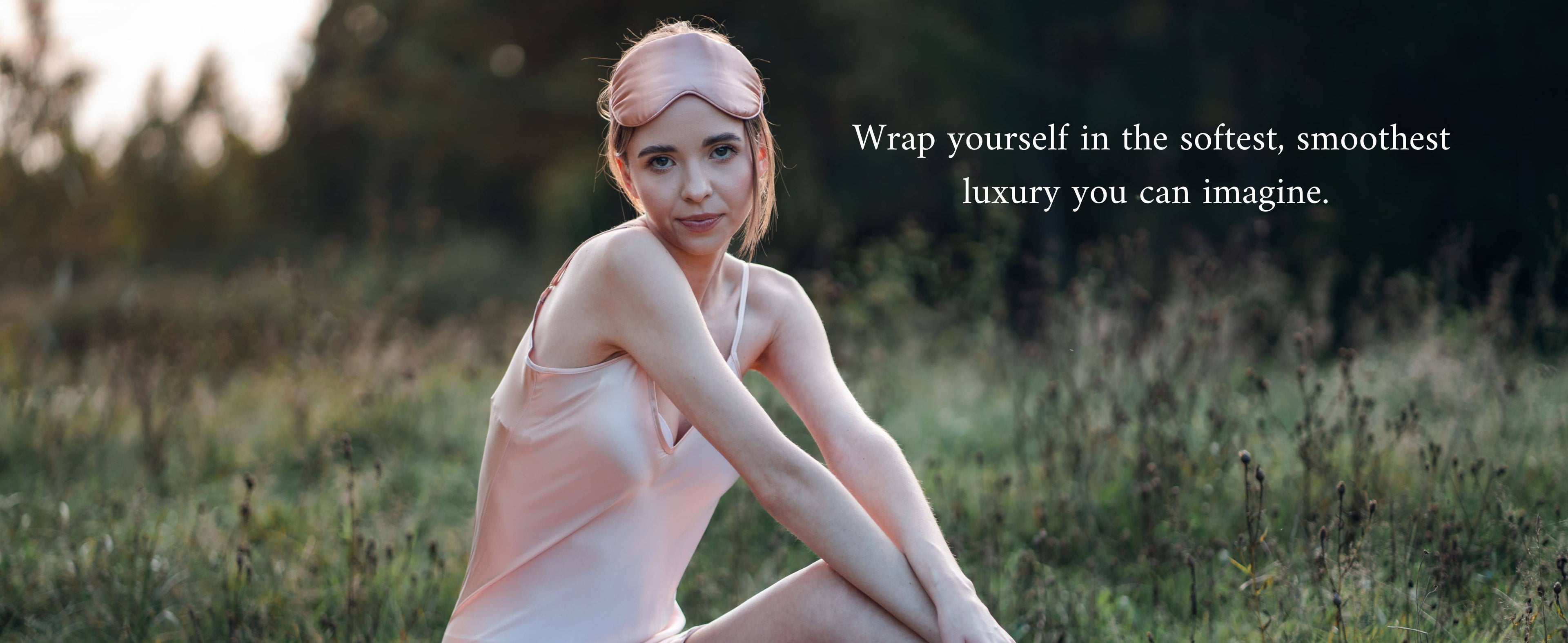 Woman wearing pink silk dress and eye mask having a picnic